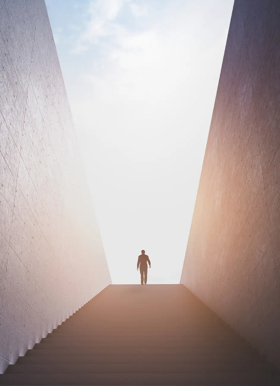 Mensch steht oben auf einer Treppe und im Hintergrund scheint die Sonne